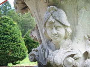 An urn in Sonnenberg Gardens smiles across the Italian garden on a summer day.